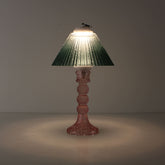 Moss green glass rechargeable lamp in a dark setting, illustrating the sunset-like atmosphere and prismatic light patterns for mood-focused bars.