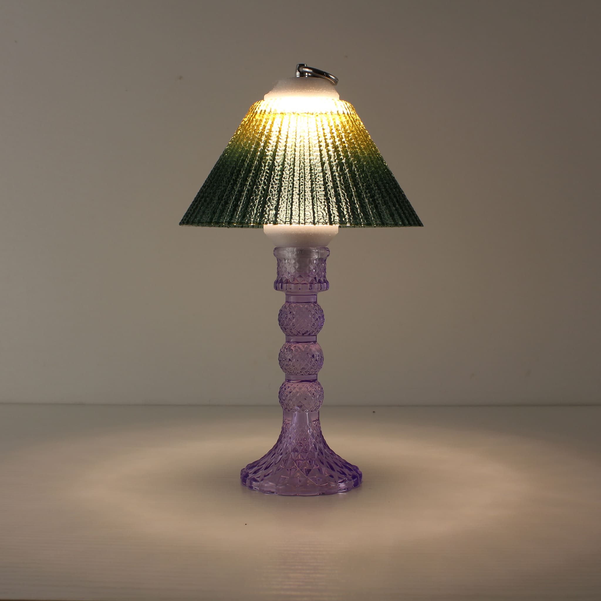 Portable wireless lantern (ON) featuring a cool purple glass base and sunlit yellow-to-green gradient shade.