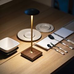 Cordless LED Table Lamp - A close-up shot of the square base design with a view of a cup and a red vase.