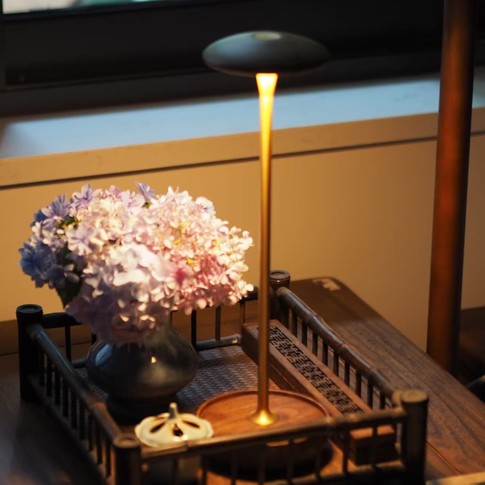 Cordless LED Table Lamp - A minimalist table lamp next to a plate setting, highlighting its use in a dining context