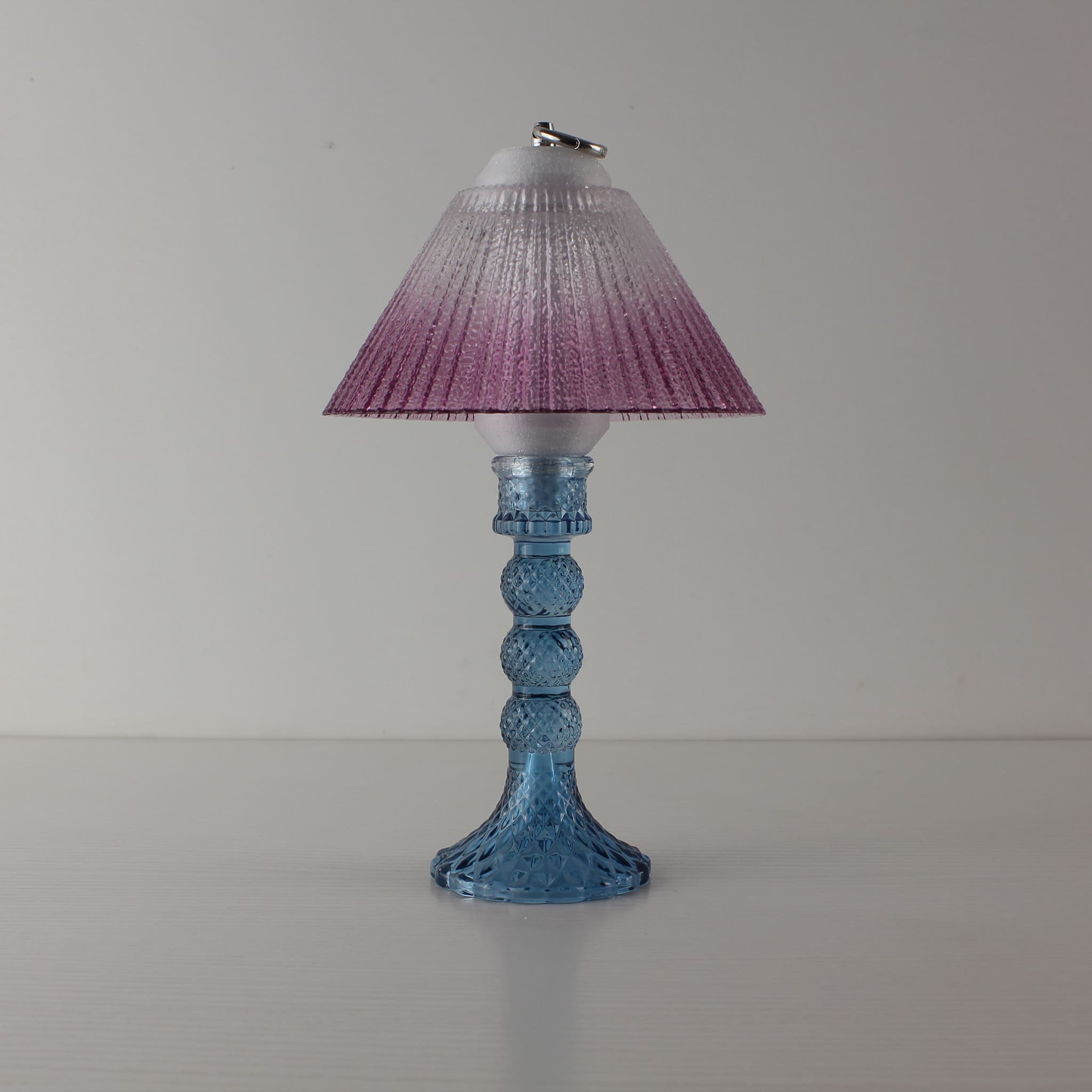 Aesthetic blue glass lamp (OFF) with warm purple gradient shade, highlighting the elegant crystal-like texture of the base.