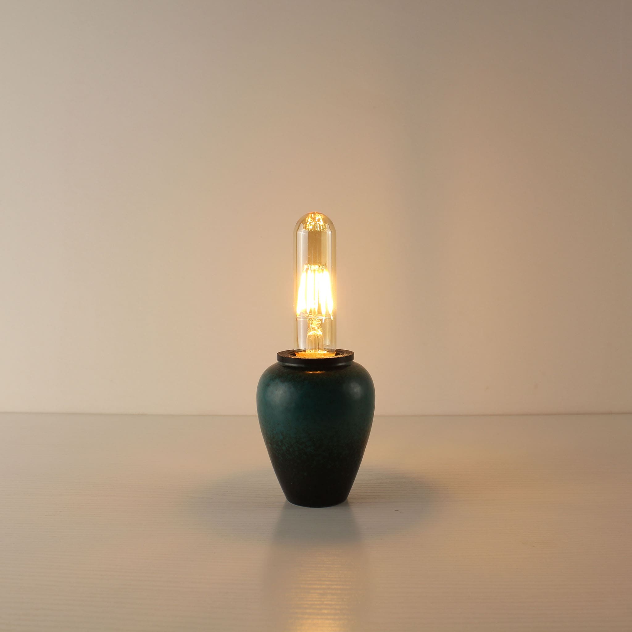 Artisanal cordless tea caddy lamp in deep kiln-turned green ceramic glaze, equipped with an elongated T125 vintage Edison bulb