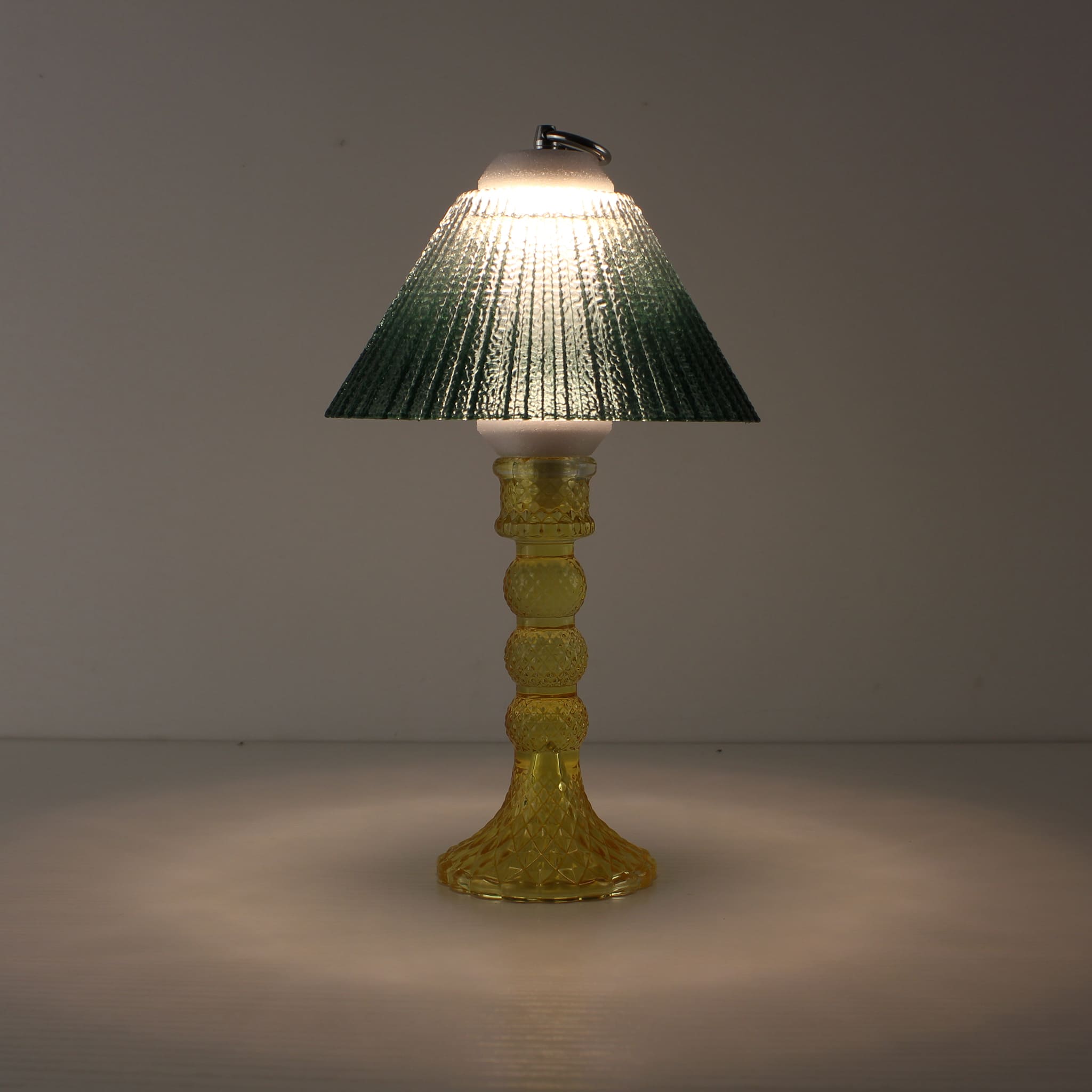 Prism battery-operated lamp (ON) with a yellow base and emerald green gradient shade for warm 3000K LED illumination.