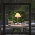 Elegant brass cordless restaurant table lamp creating ambient outdoor dining lighting