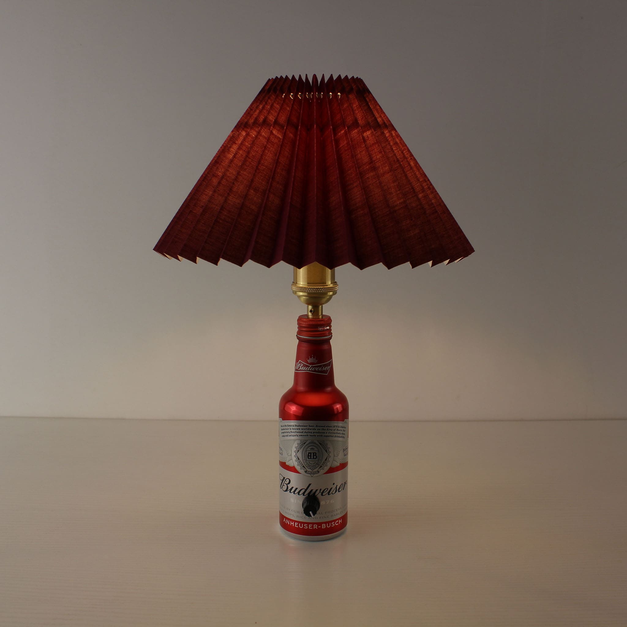 Upcycled Budweiser bottle table lamp featuring a premium burgundy pleated shade