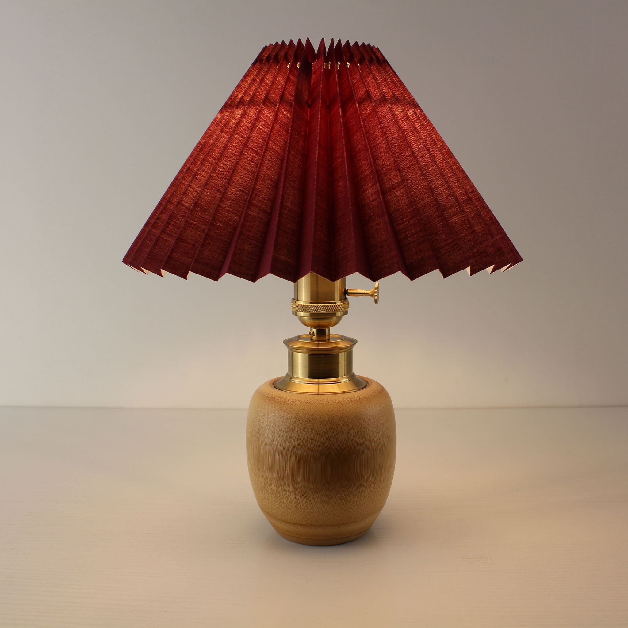 Portable rechargeable bamboo lamp with burgundy pleated shade, Japandi aesthetic for bedside and nightstand lighting