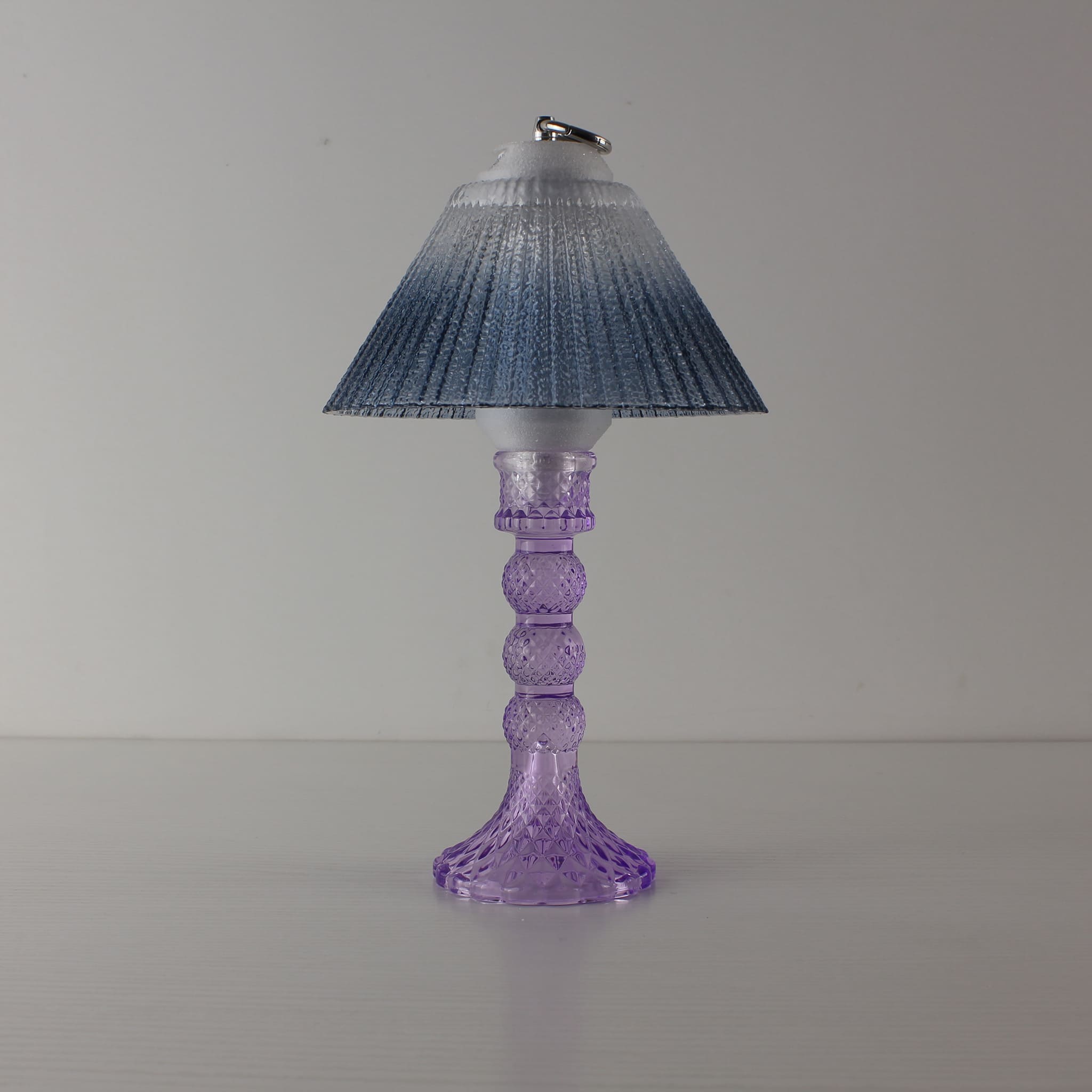 Prism glass centerpiece (OFF) with cool purple faceted base and blue gradient shade, showing modern clarity in daylight.