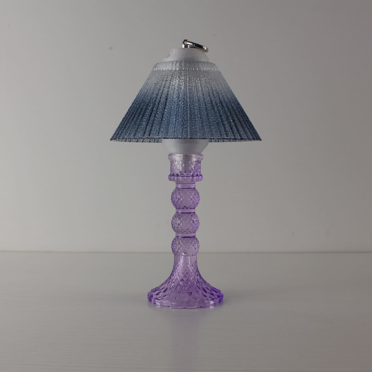 Prism glass centerpiece (OFF) with cool purple faceted base and blue gradient shade, showing modern clarity in daylight.