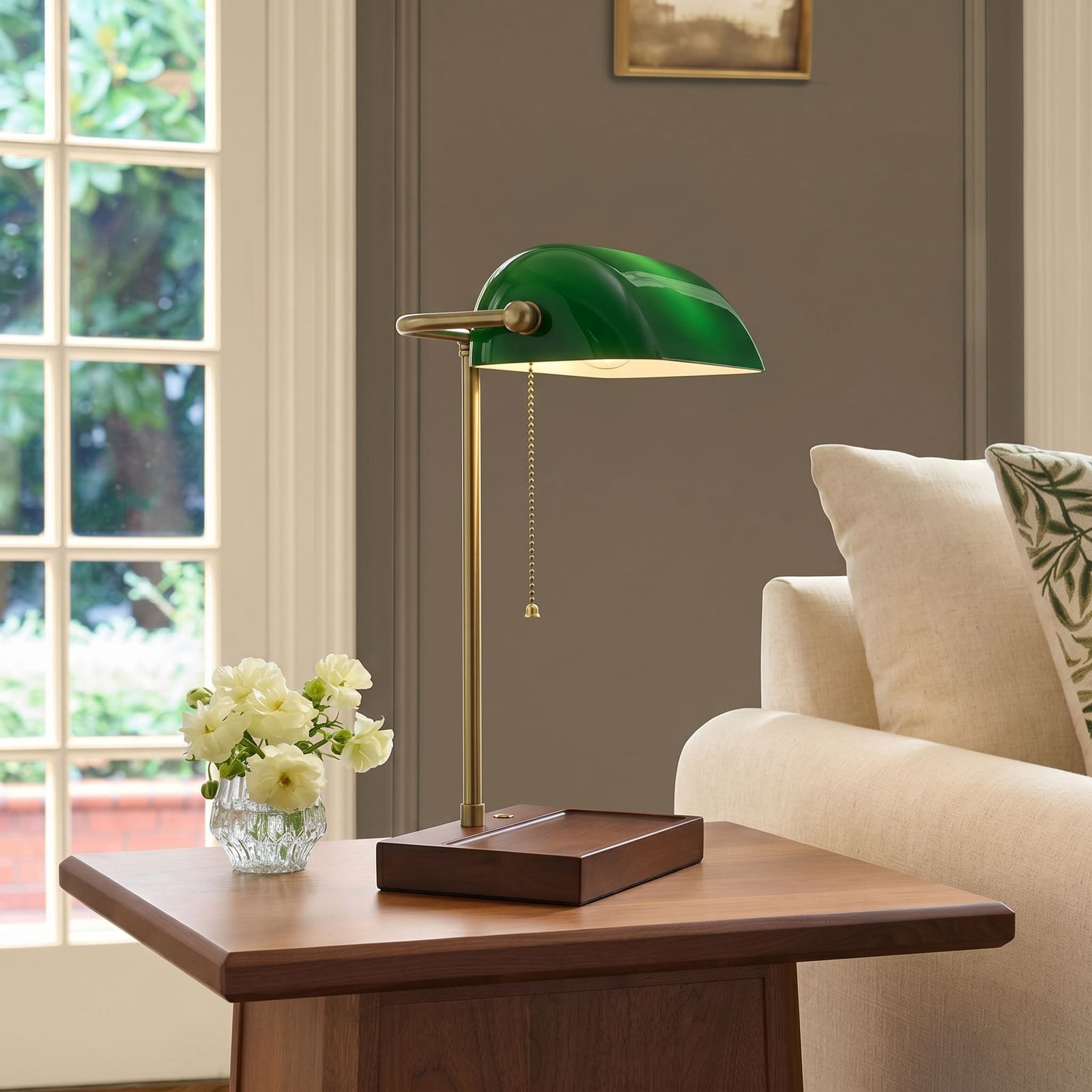 Cordless green bankers lamp with wooden base on a side table in a bright living room