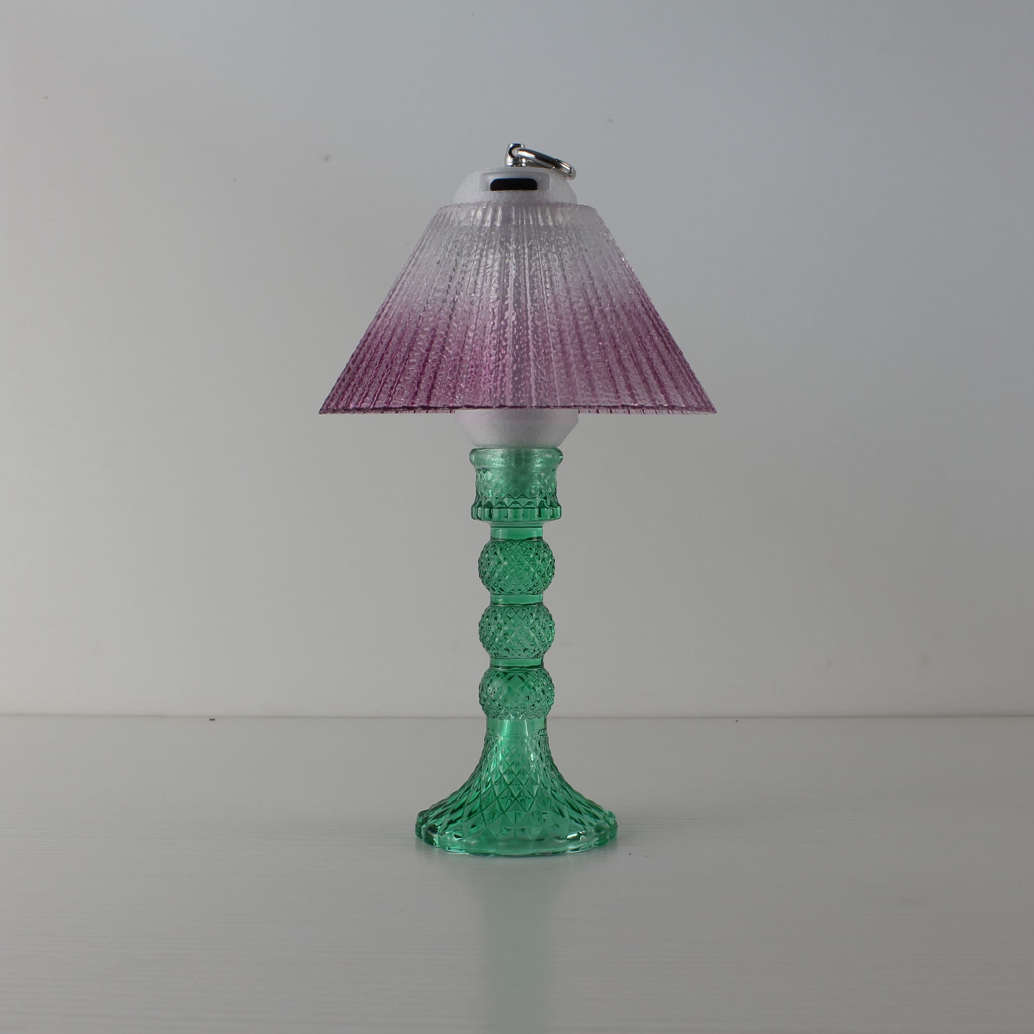 Prism decorative lamp (OFF) with cyan base and warm purple gradient shade in natural daylight.