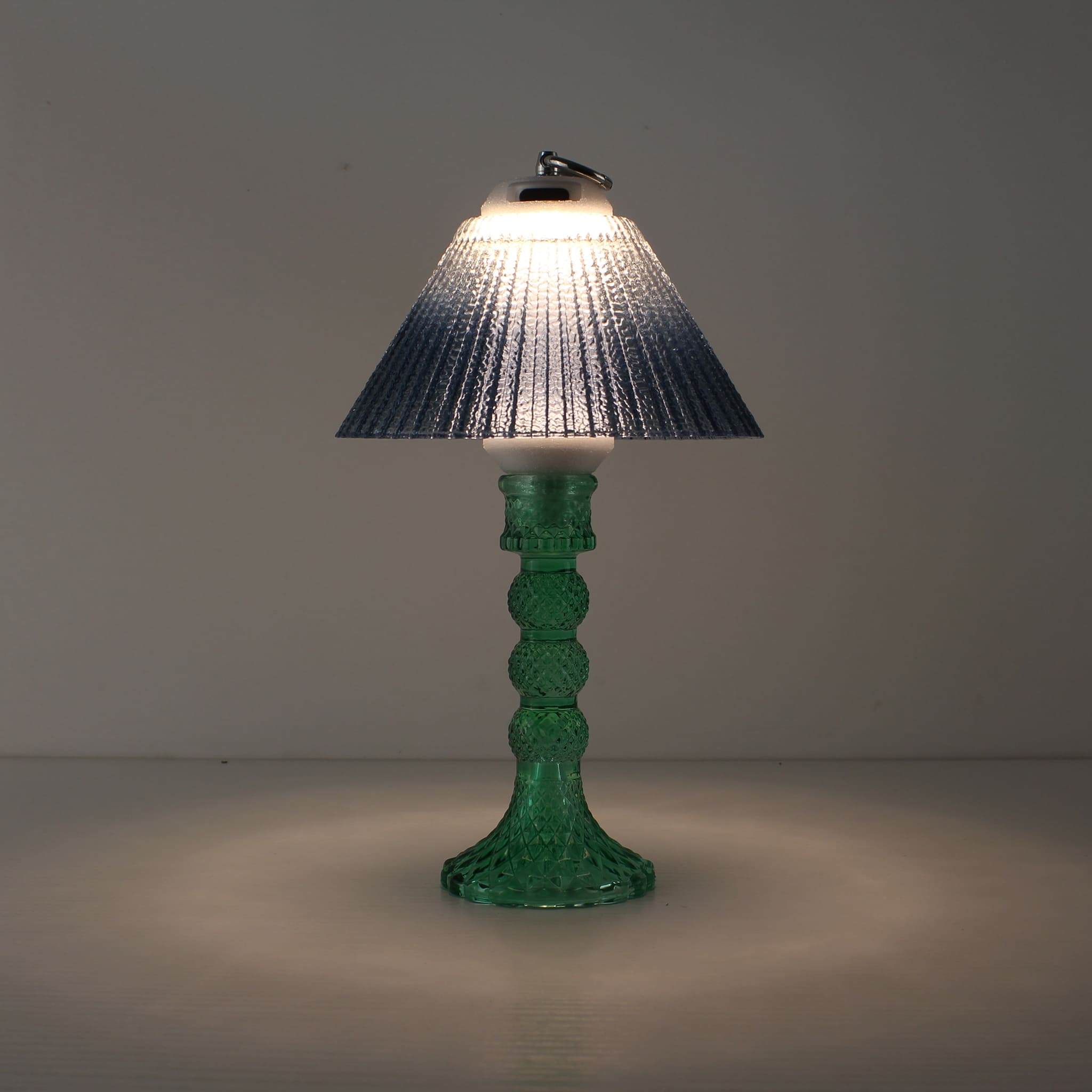 Prism rechargeable lantern (ON) with cyan base and blue gradient shade emitting a cool prismatic glow.