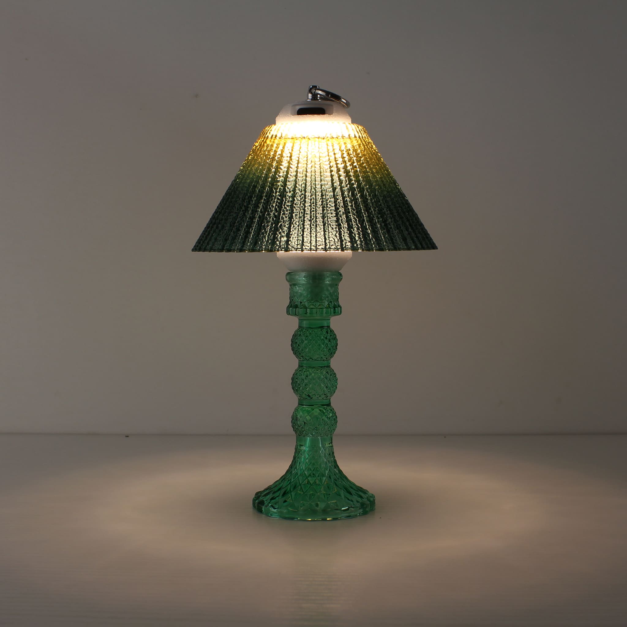 Prism portable light (ON) with cyan base and yellow-to-green gradient shade for a warm sunlit effect.