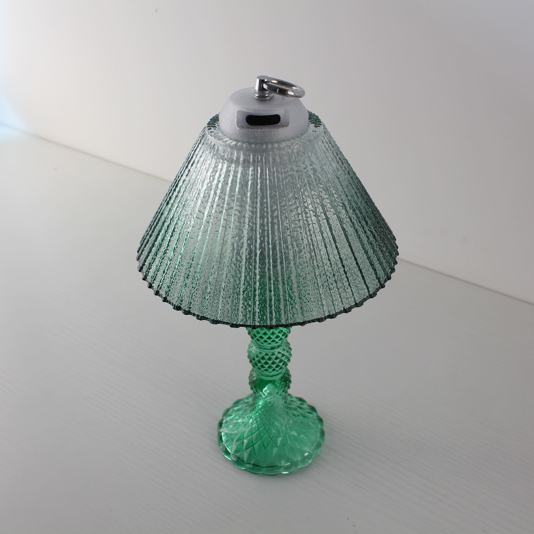 Wide view of the Prism glass lantern (OFF) in daylight, highlighting the elegant cyan faceted glass base.