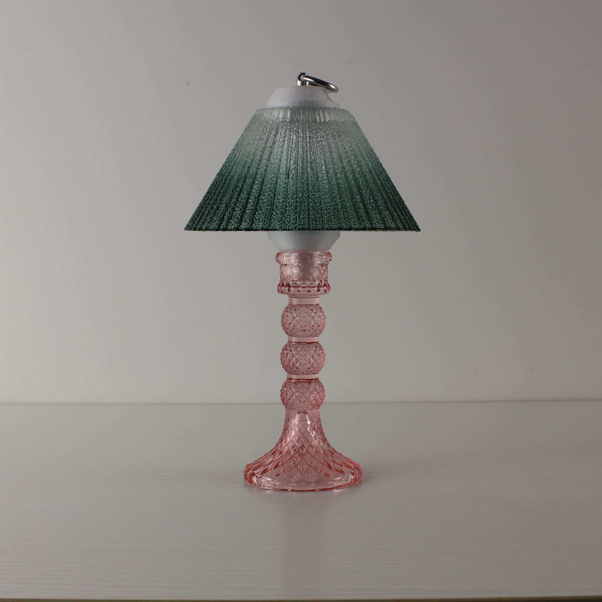 Dark green textured glass lantern with a pink faceted glass base, emphasizing the cordless and portable design for flexible commercial decor