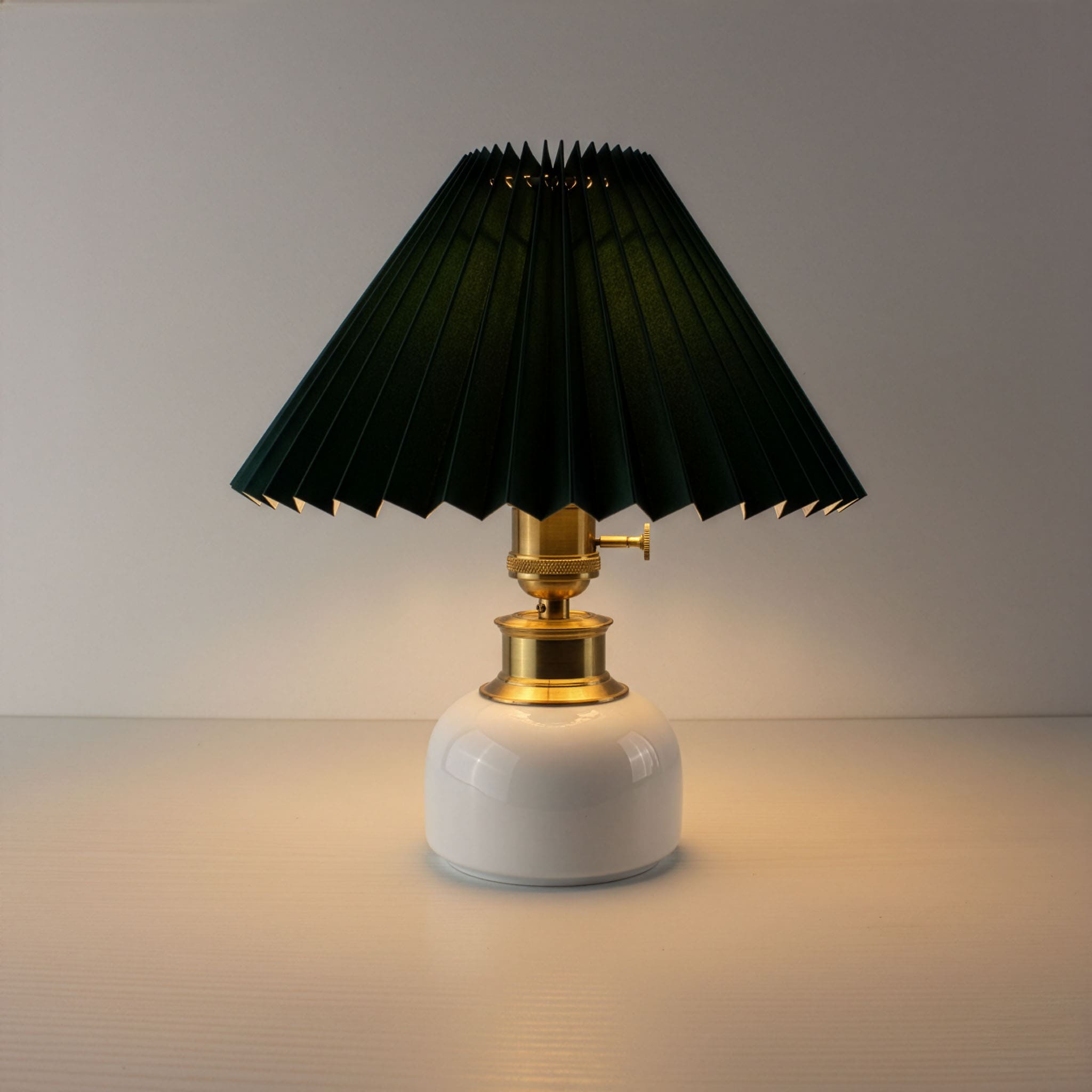 Premium cordless table lamp with dark green pleated shade and warm LED glow on a white ceramic base.