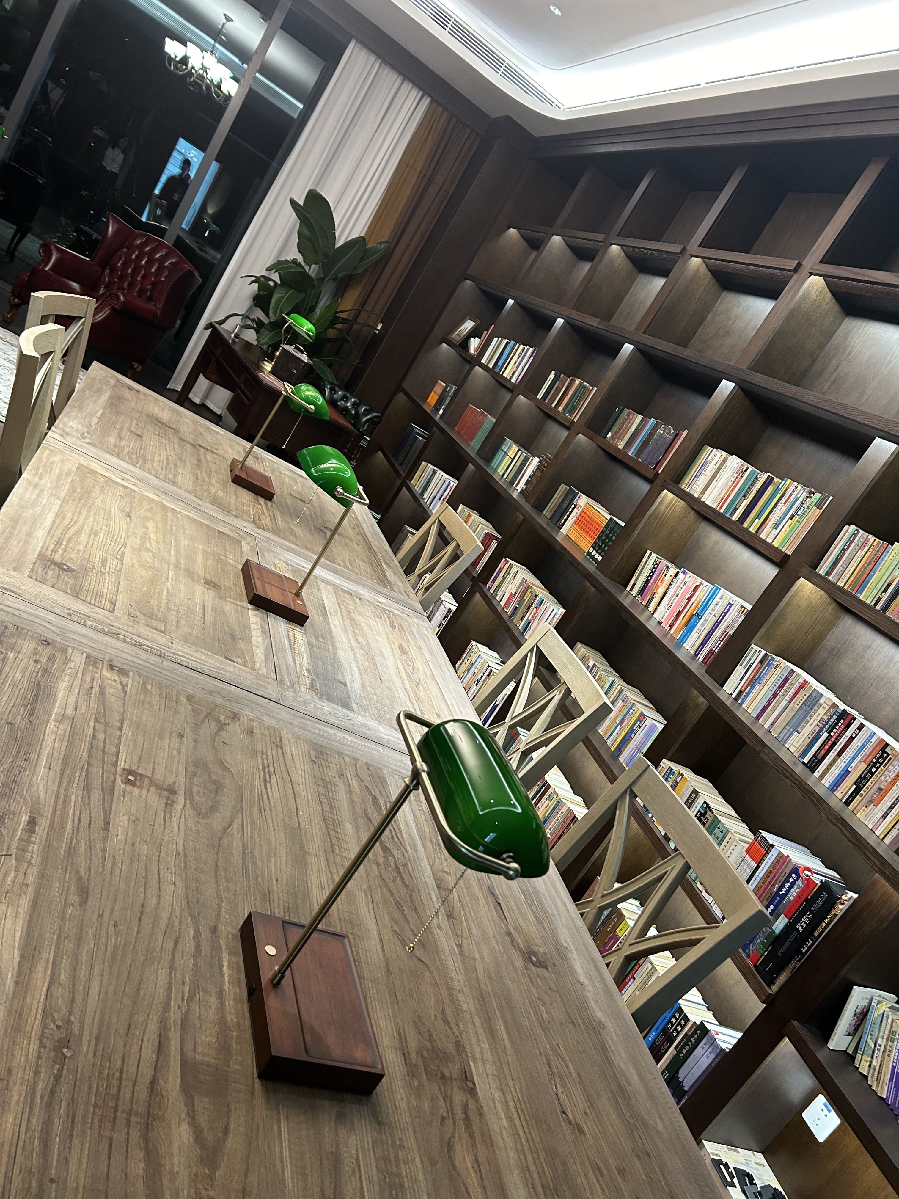 Green bankers lamps providing elegant task lighting in a luxury library interior