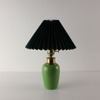 Luxury green ceramic wireless lamp with a forest green pleated shade and brass hardware, vintage MCM style.
