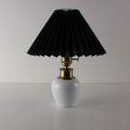 Mid-century modern white ceramic rechargeable lamp with a forest green pleated fabric shade.