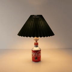 Front view of the industrial style Coca-Cola bottle lamp with a dark green pleated shade in a daylight setting.