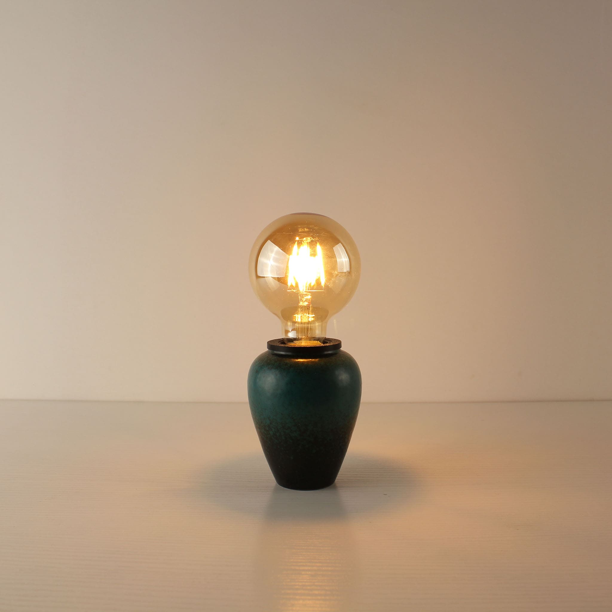 Handcrafted kiln-turned green ceramic cordless table lamp featuring a large round A80 vintage Edison LED bulb with a warm 2700K glow