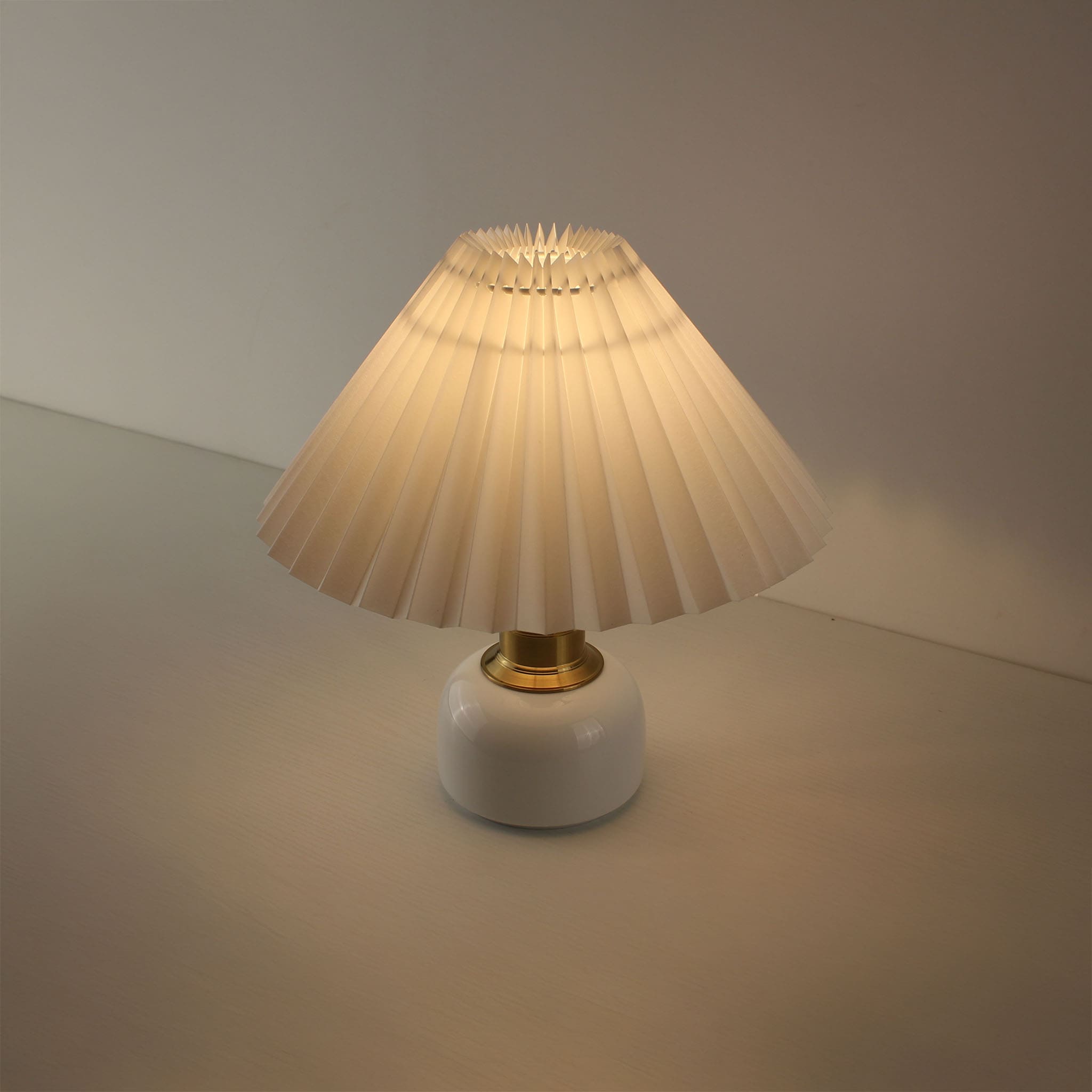Mid-Century Modern wireless lamp featuring a white pottery base and elegant pleated shade for living room.