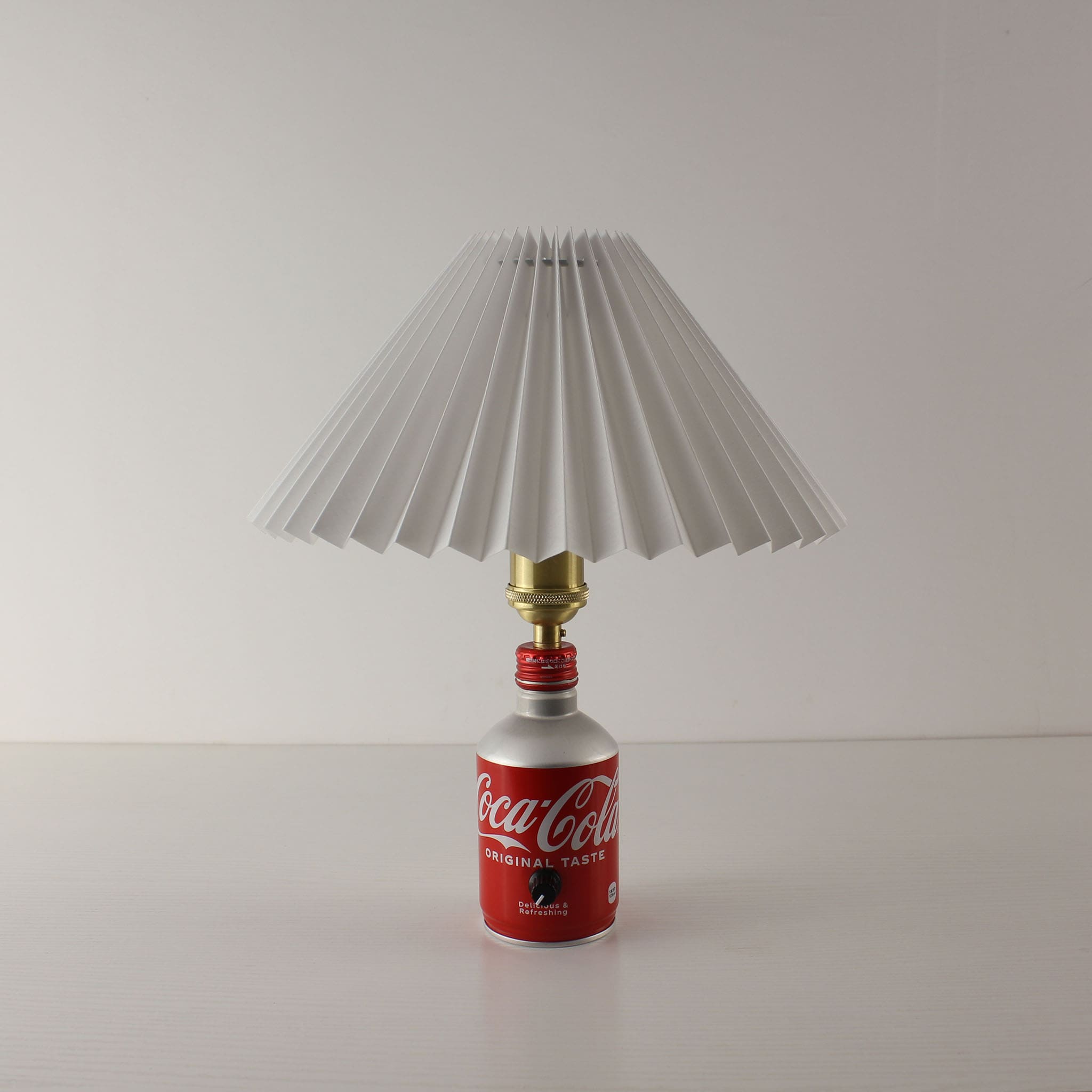 minimalist front view of the white shade Coca-Cola lamp turned off, focusing on its role as a pop-art home decor piece