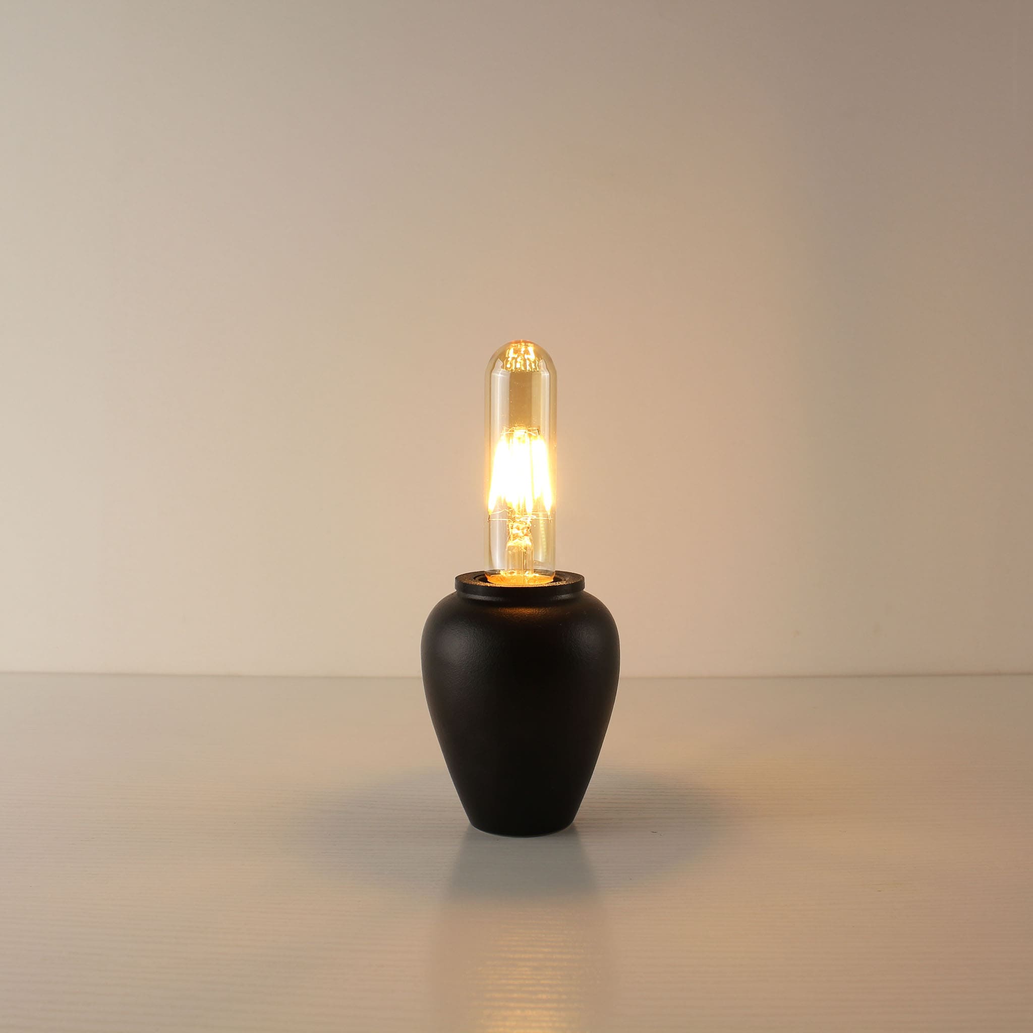 Modern Zen-inspired black rechargeable lamp with an elongated T125 vintage Edison bulb, perfect for bedside or restaurant table lighting