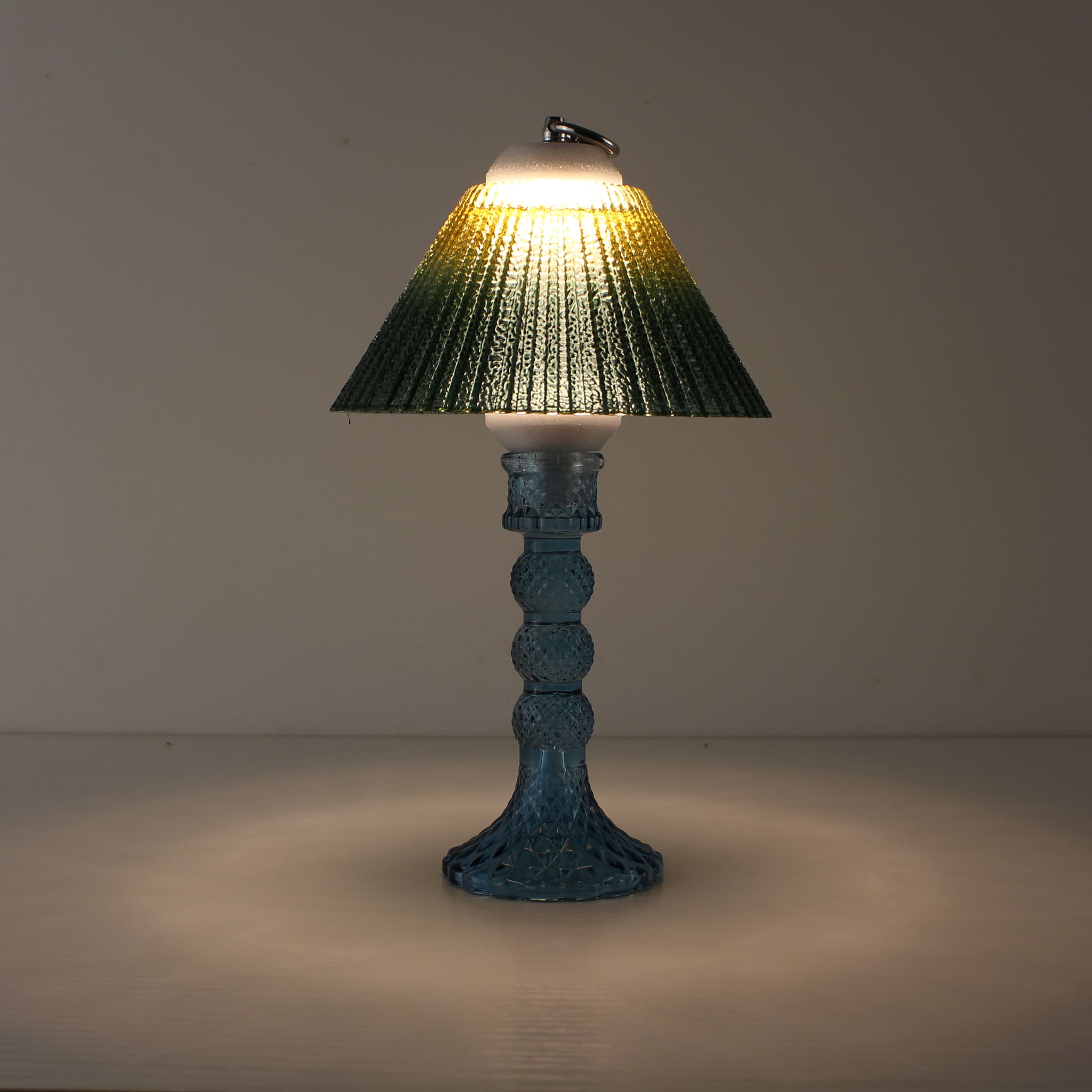 Portable wireless lantern (ON) featuring a deep blue glass base and sunlit yellow-to-green gradient shade for warm contrast.