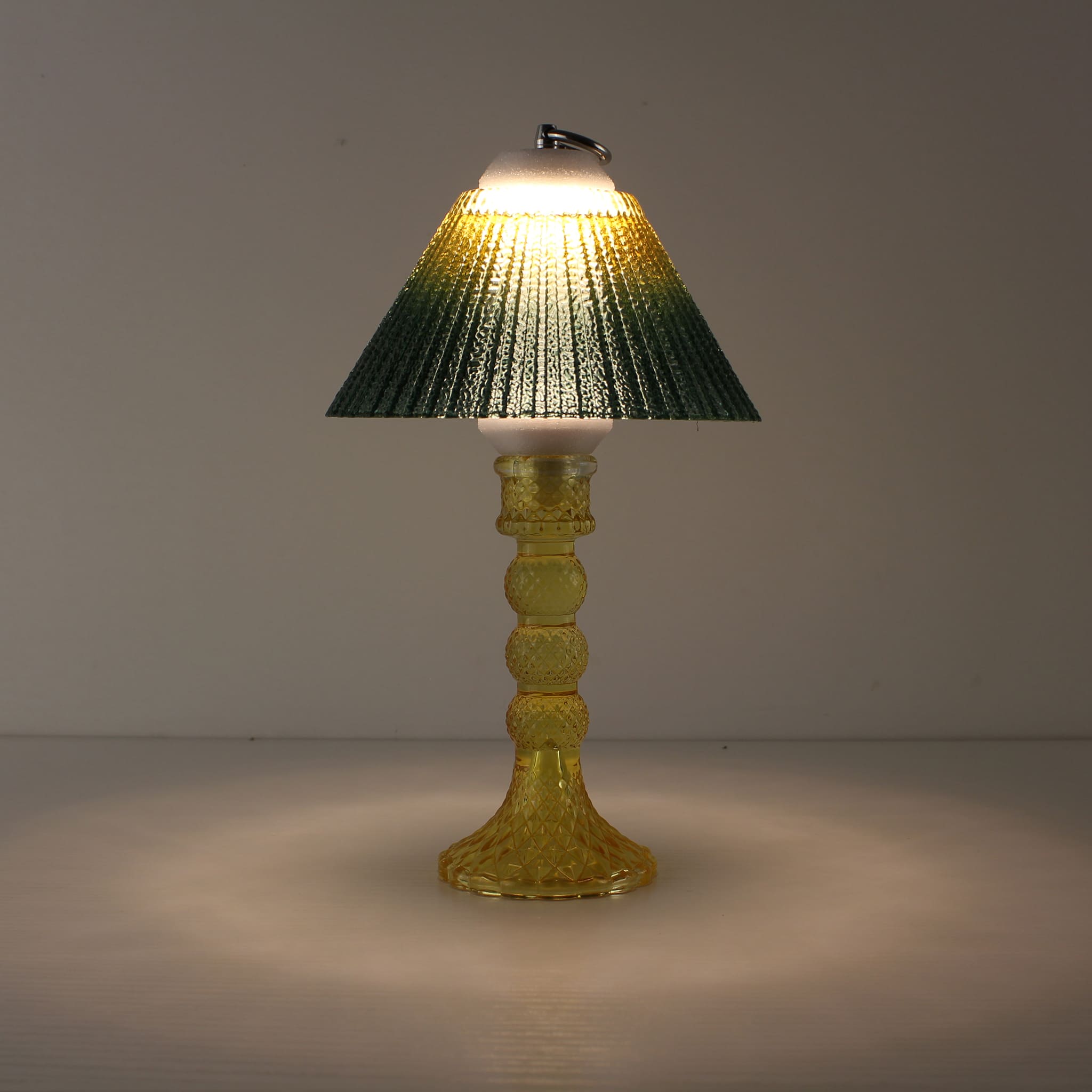 Portable wireless lantern (ON) featuring an amber yellow glass base and sunlit yellow-to-green gradient shade.