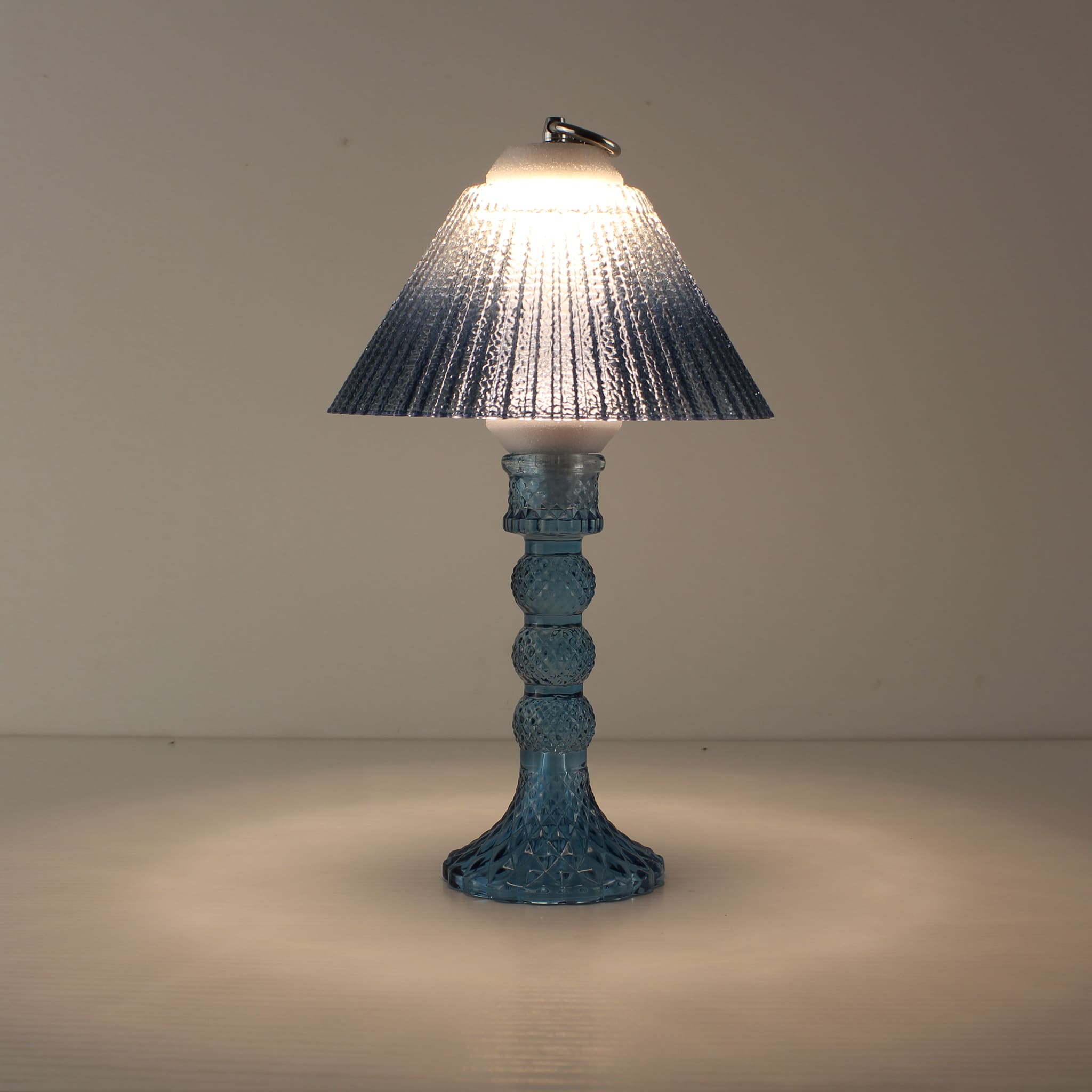 Prism rechargeable lantern (ON) with sapphire blue faceted base and matching blue gradient shade, creating a cool immersive glow.