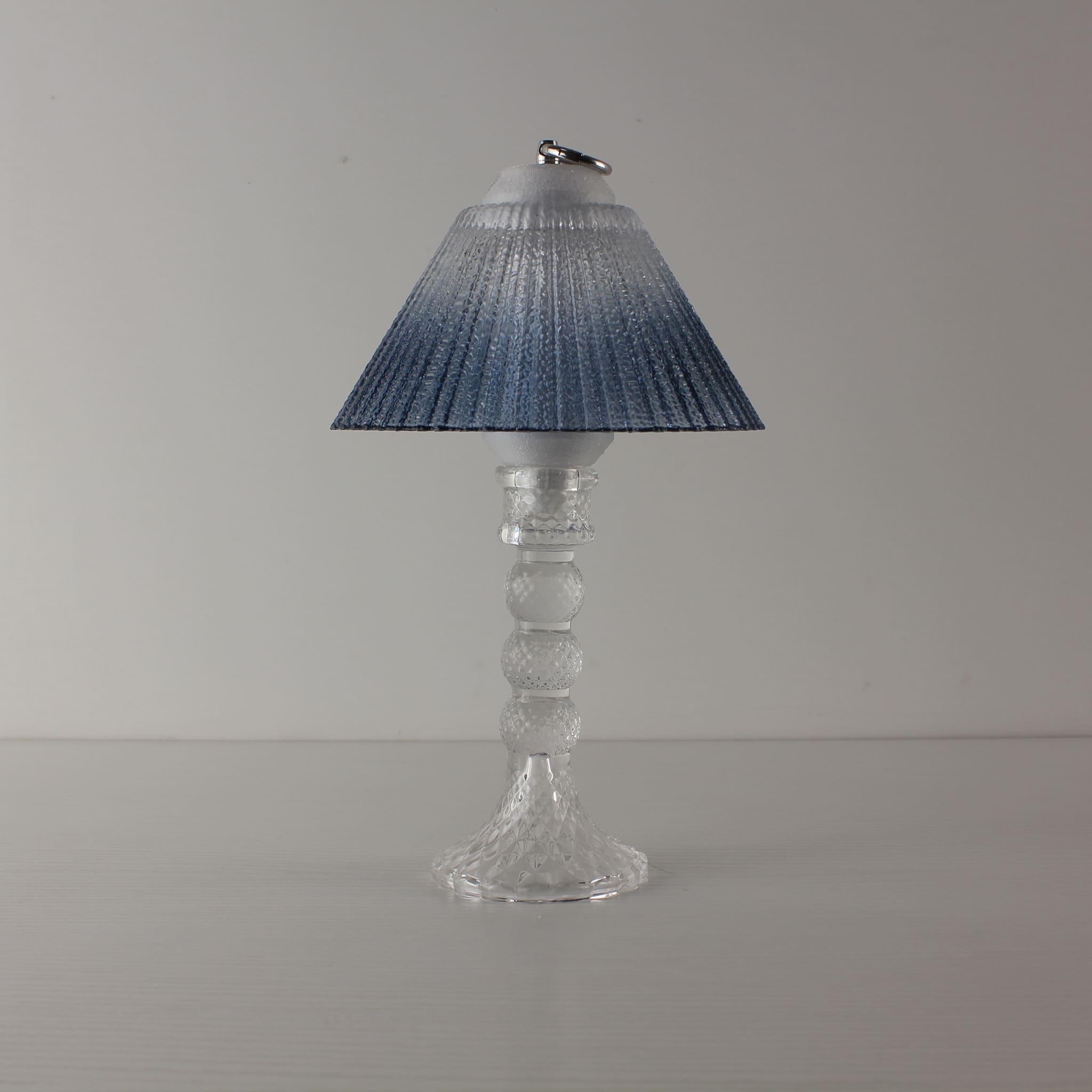 Prism glass lantern (OFF) with clear faceted base and blue gradient shade, showcasing modern clarity in daylight.