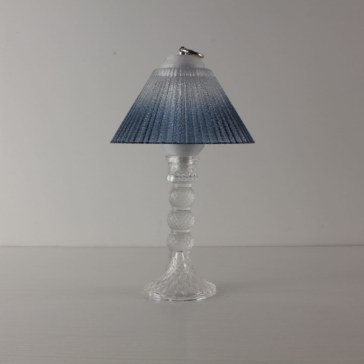 Prism glass lantern (OFF) with clear faceted base and blue gradient shade, showcasing modern clarity in daylight.