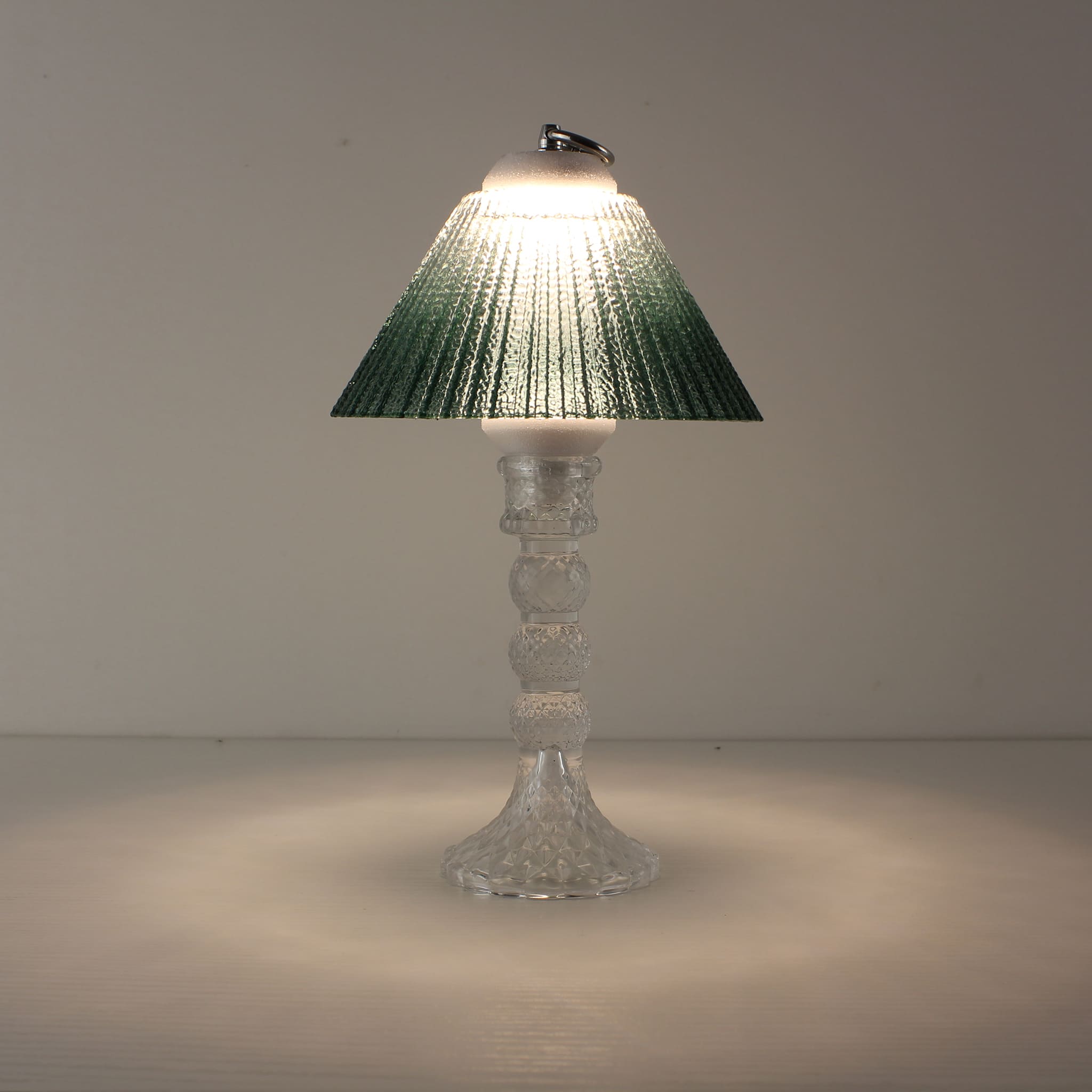 Battery powered glass lantern (ON) with clear base and emerald green gradient shade showing textured 3000K LED light.