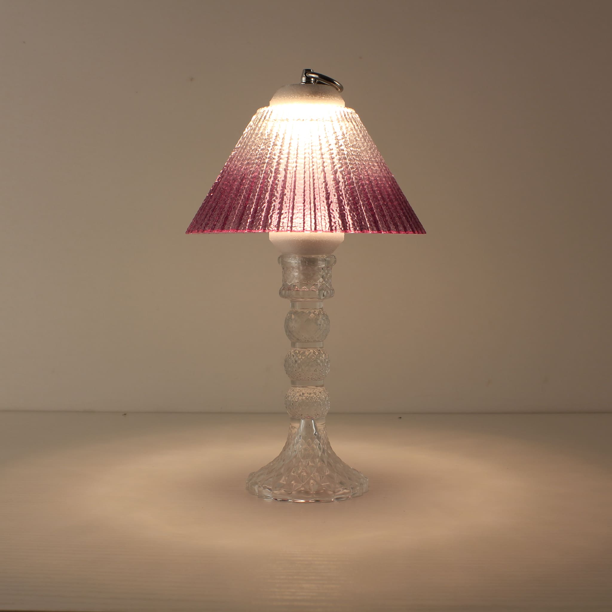 Cordless decorative table lamp (ON) with clear glass base and warm purple gradient shade for romantic ambiance.