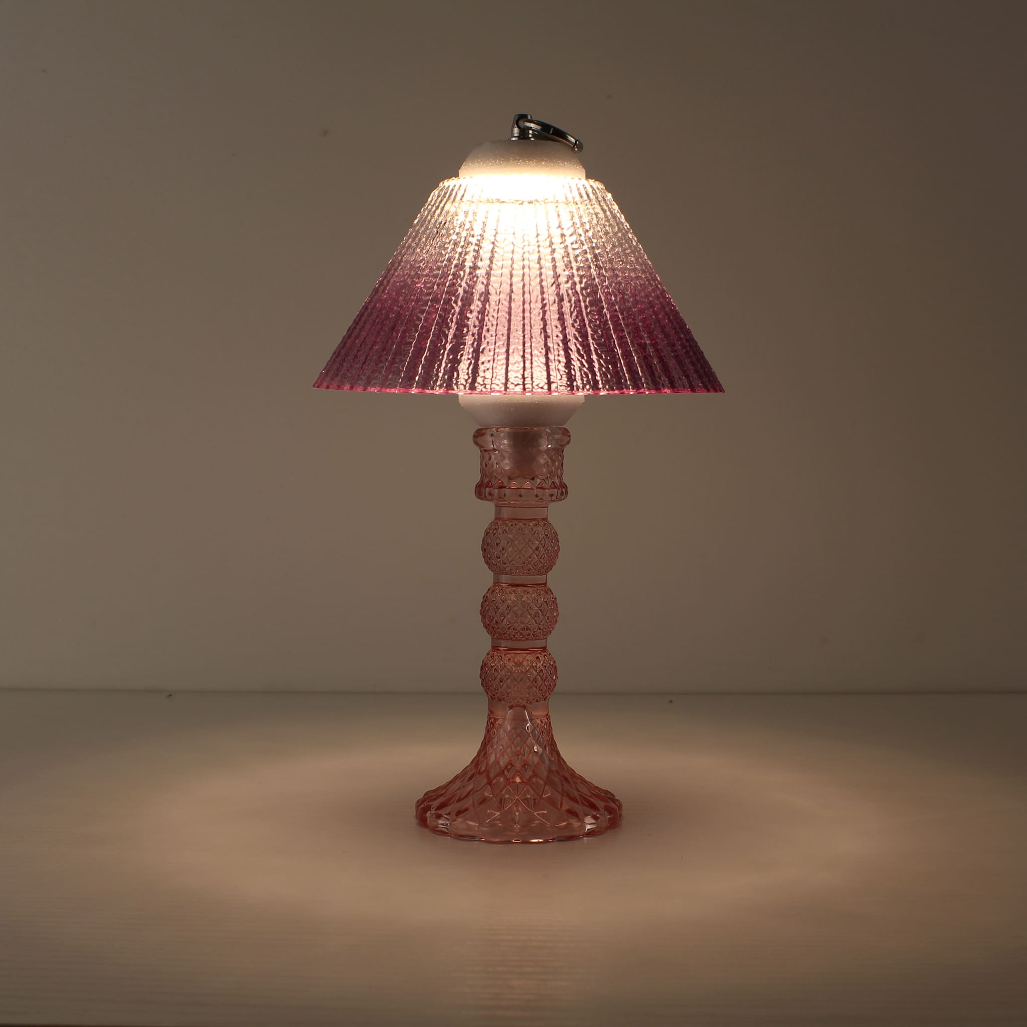 Purple glass table lamp turned on, emitting a warm 3000K glow through prismatic glass, creating a romantic candle-like atmosphere for bar counters.