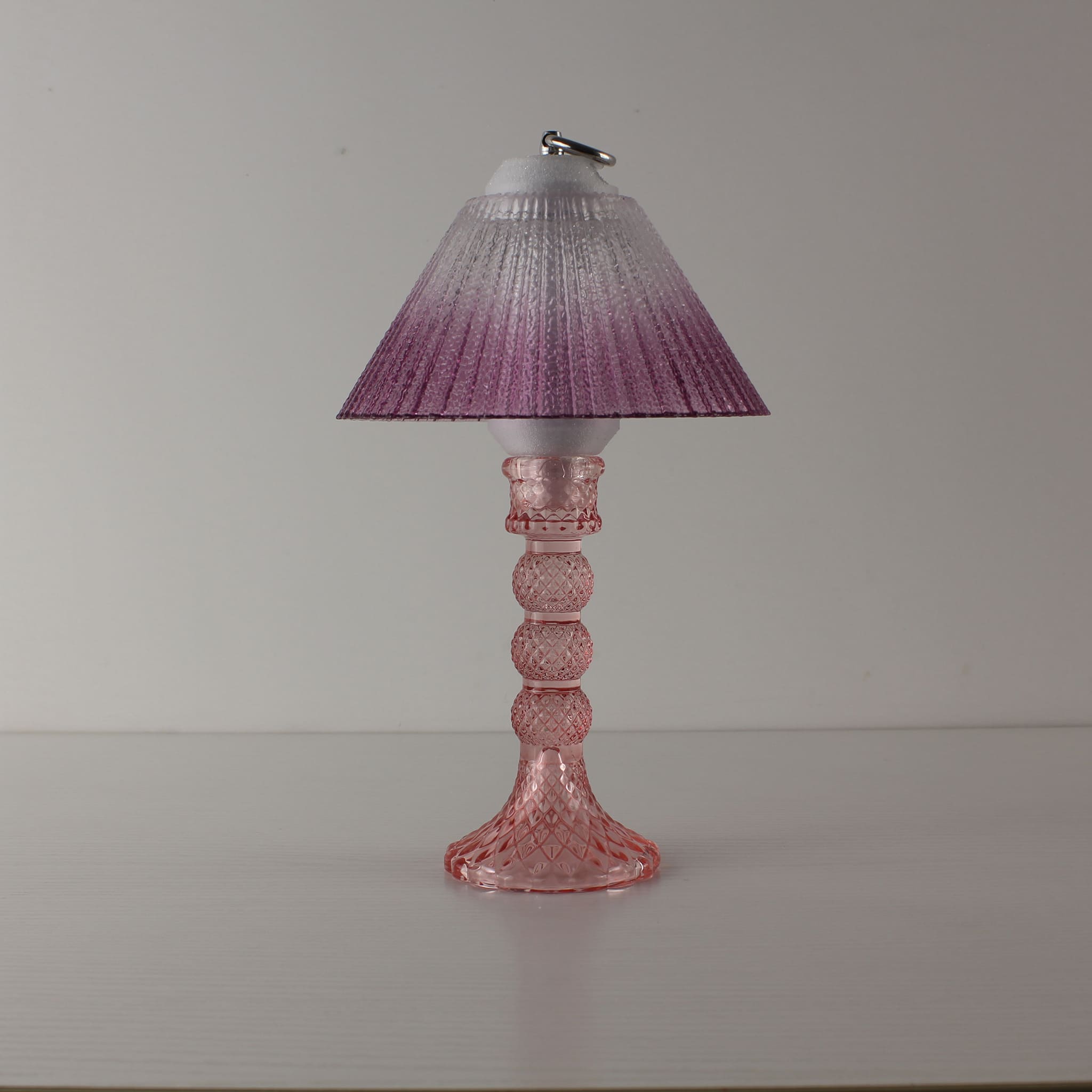 A cordless table lamp with a purple gradient textured glass shade and pink faceted glass base, shown turned off to highlight the elegant glass craftsmanship for bars.