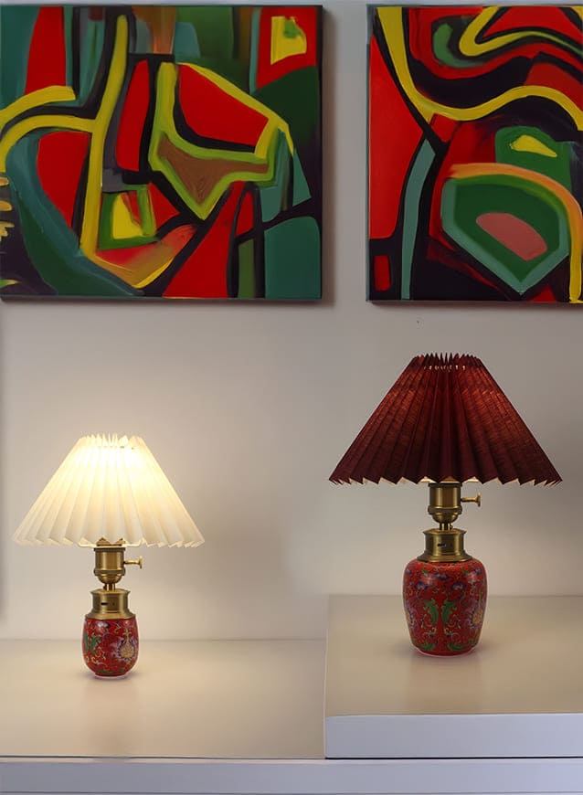 Red ceramic cordless table lamp with pleated fabric shade and warm ambient lighting