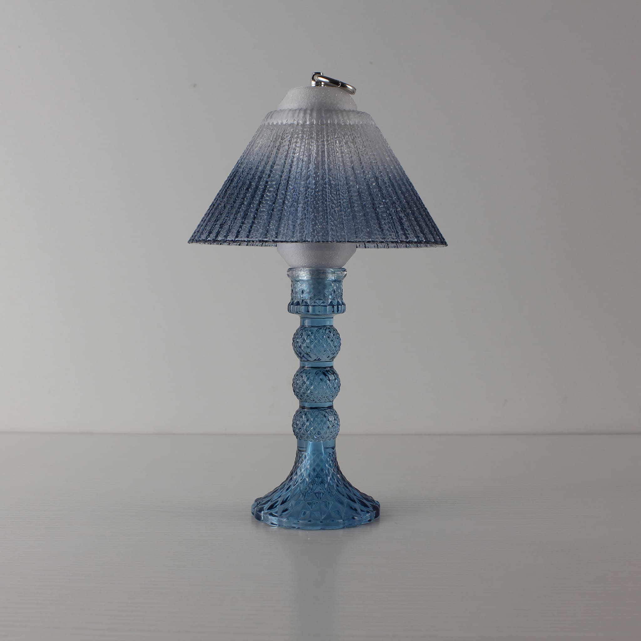 Prism glass centerpiece (OFF) with sapphire blue faceted base and blue gradient shade, showing elegant modern clarity in daylight.