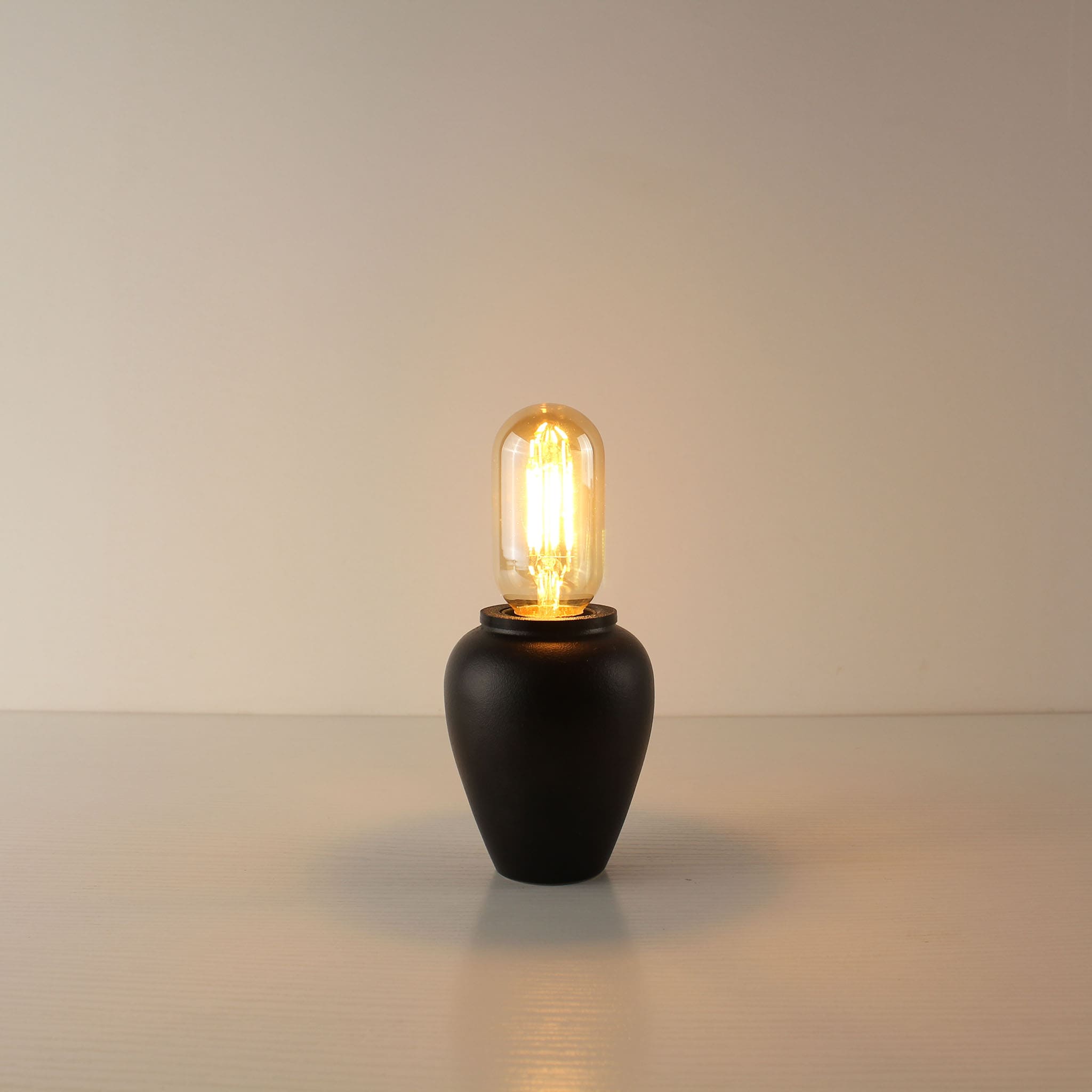 Sleek handcrafted black ceramic portable lamp equipped with a compact T45 tube-shaped vintage LED bulb