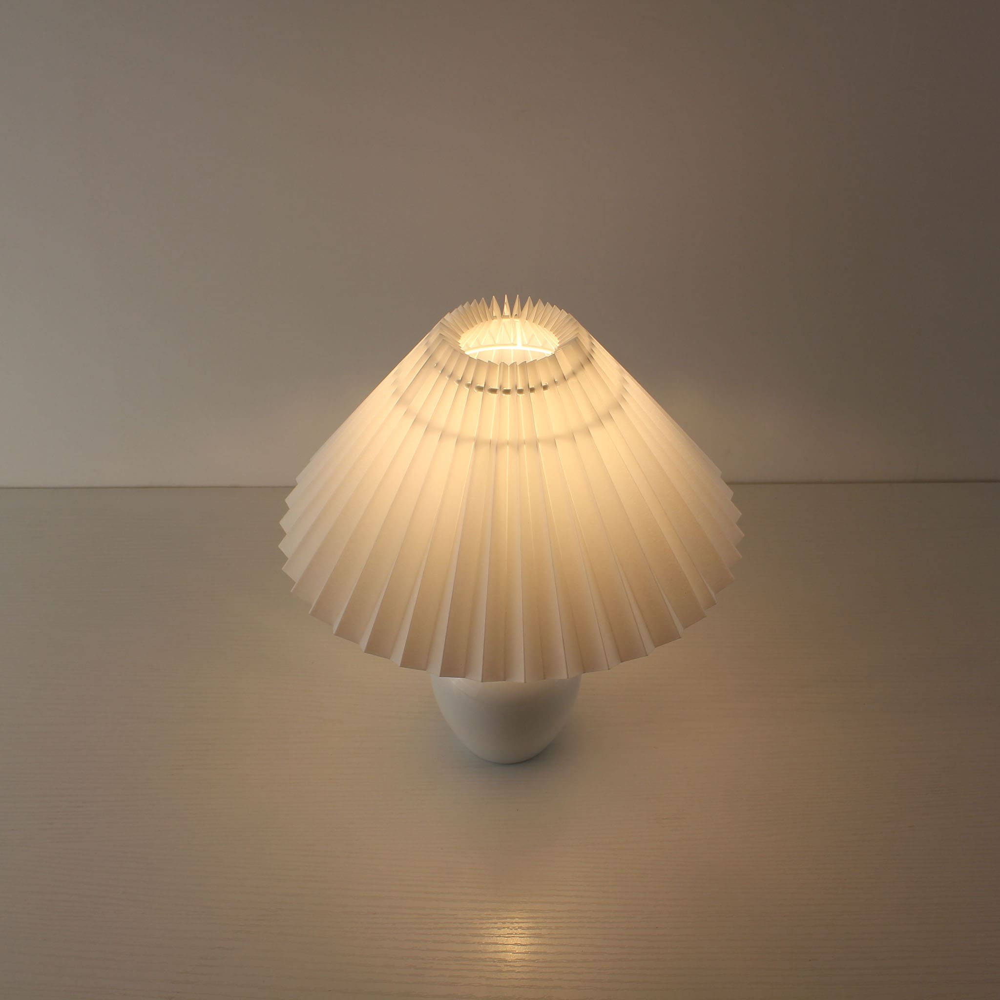 Top-down perspective of the glowing pleated shade providing 360-degree soft ambient light, ideal for restaurant tables.