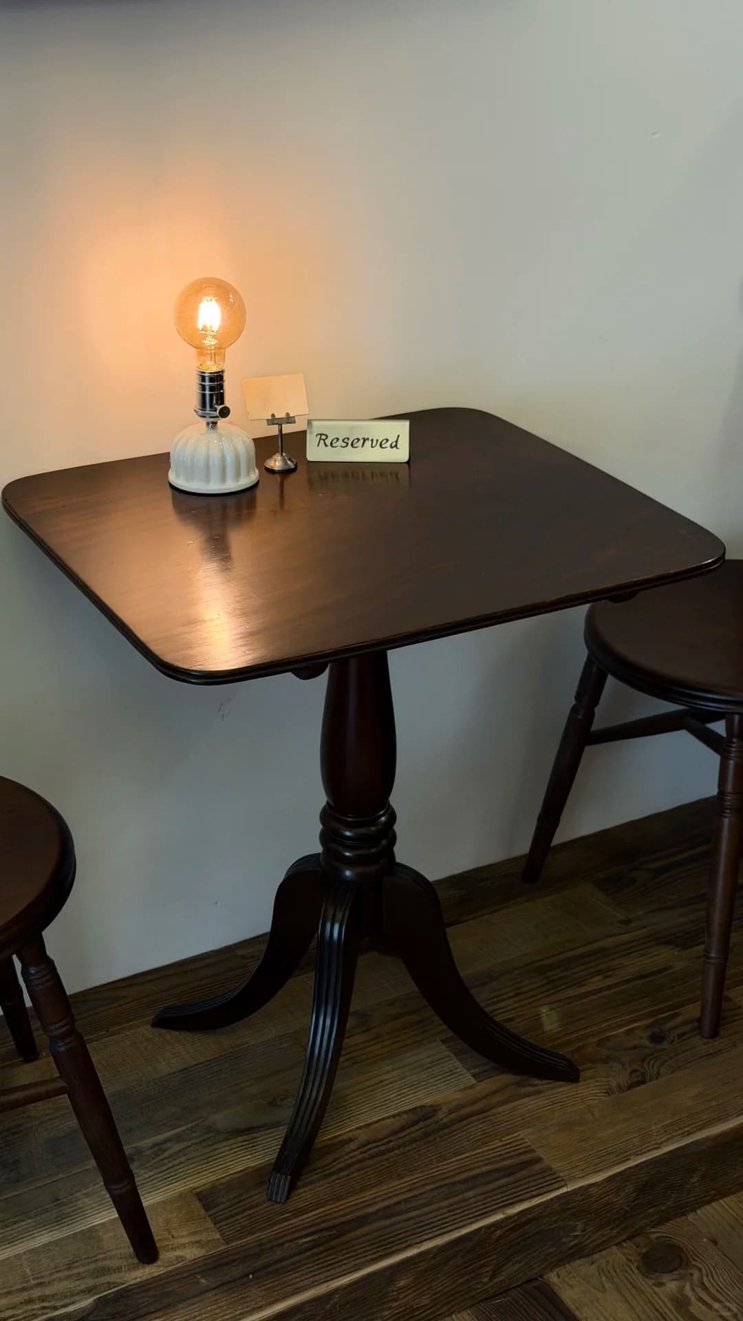 Vintage cordless Edison bulb lamp displayed on a wooden cafe table with warm ambient glow