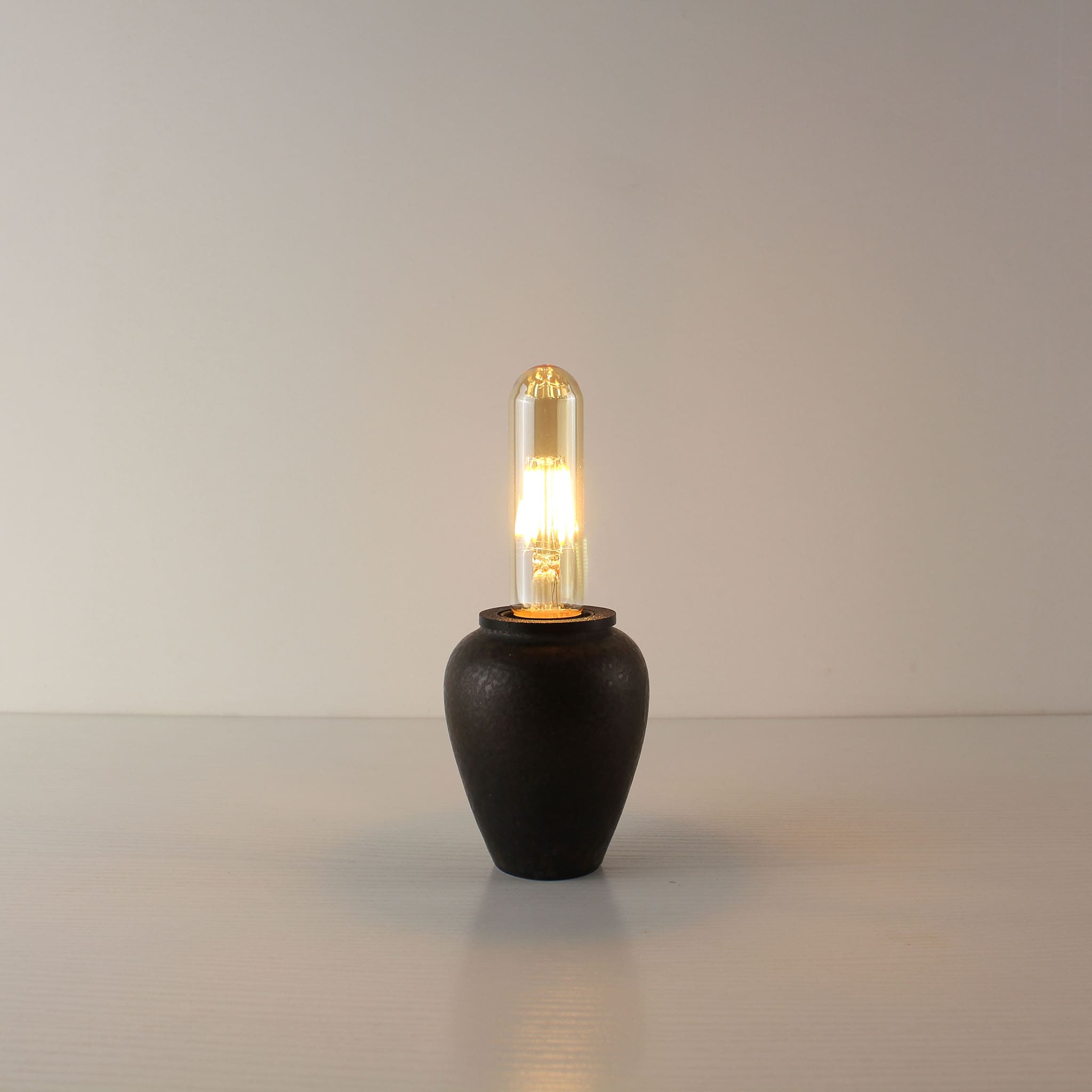 Wabi-sabi inspired industrial rust rechargeable lamp with an elongated T125 vintage bulb, perfect for minimalist sanctuary lighting