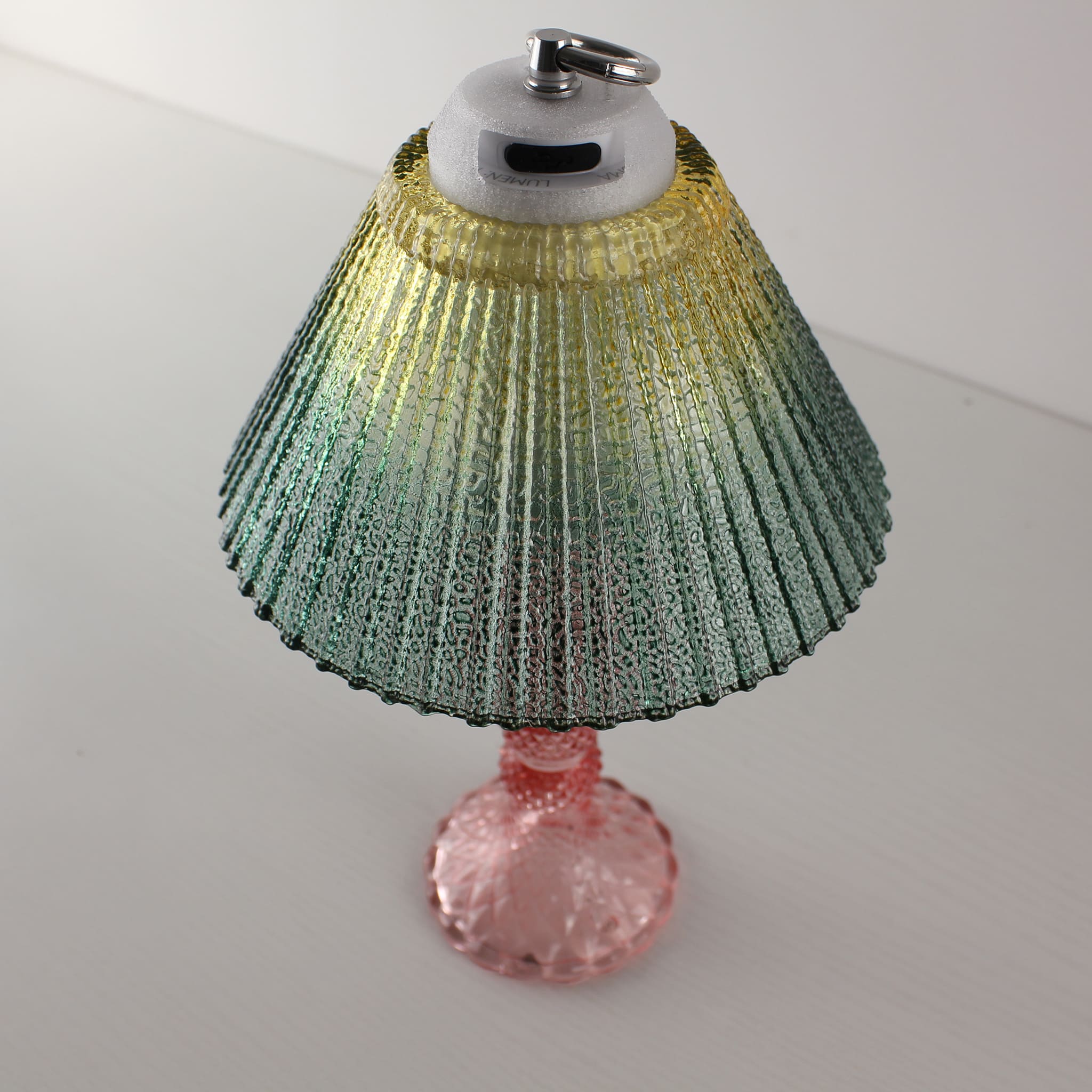 High-angle detail view of a yellow-green textured glass lamp, showing the modern dimming module and hanging ring for portable commercial use.