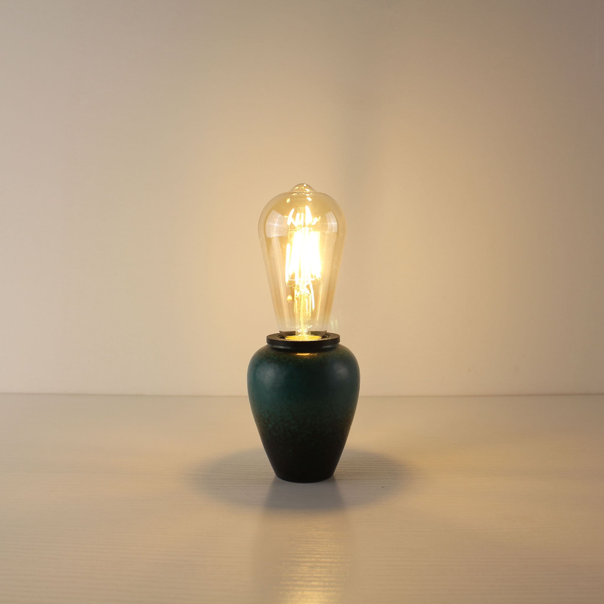 Zen-inspired rechargeable ceramic lamp in a unique kiln-turned green finish, paired with a classic teardrop ST64 Edison LED bulb